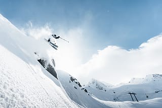 Max skiing off a cliff into fresh powder